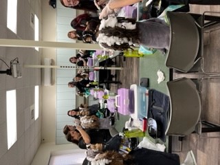 class of students working on hair manikins